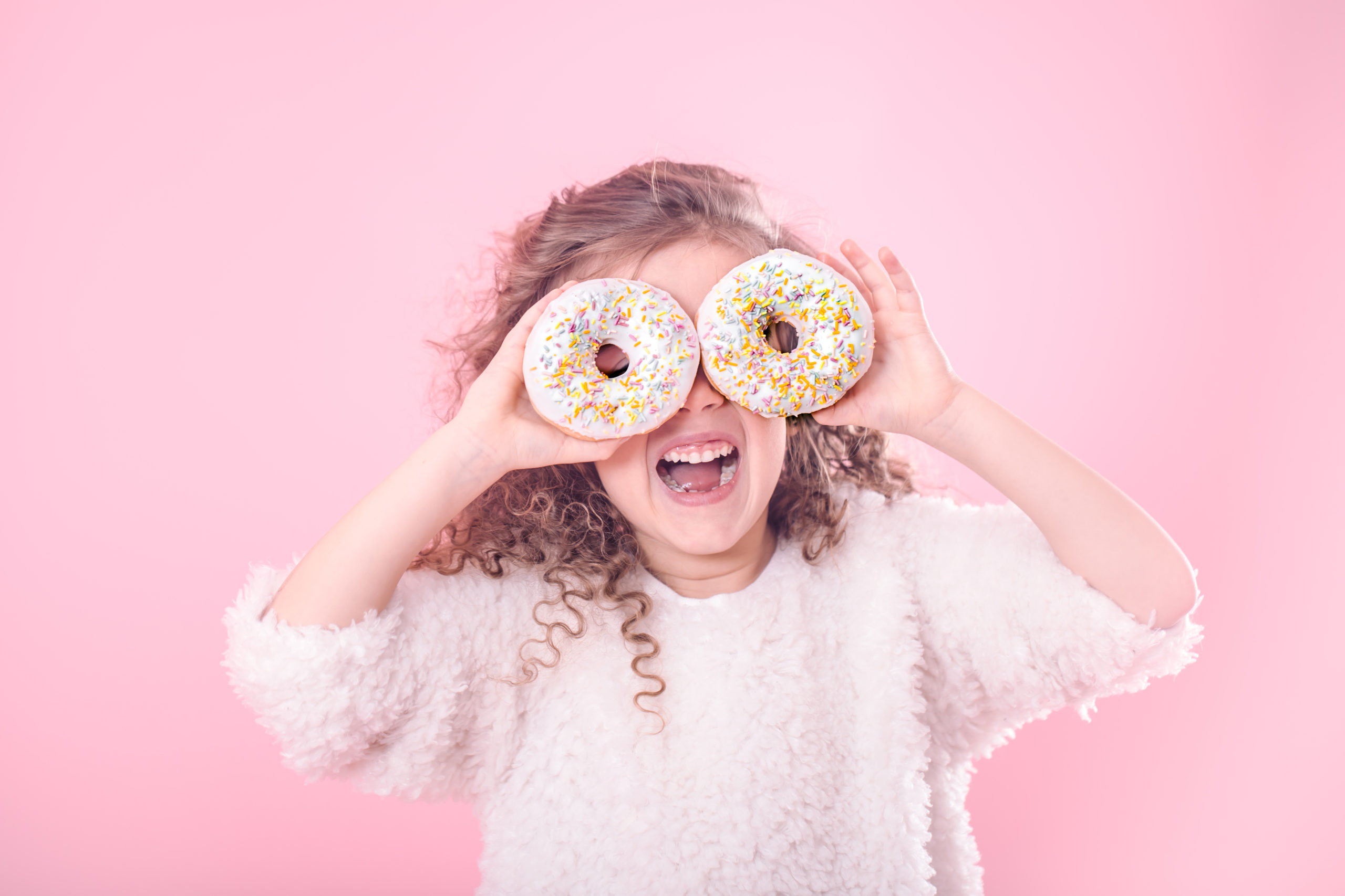 portrait little smiling girl with donuts 1 scaled