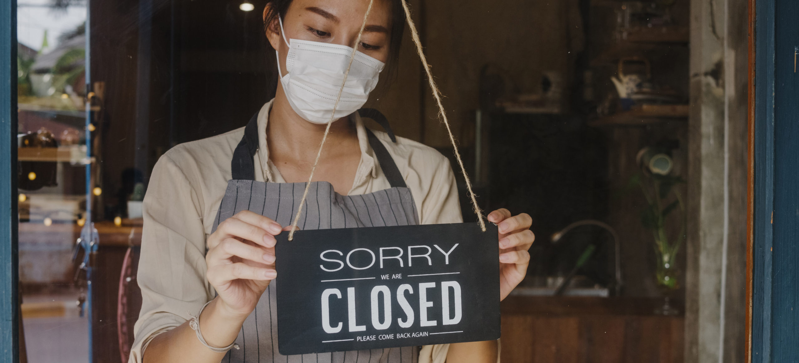 young asian girl wear face mask turning sign from open closed sign glass door cafe after coronavirus lockdown quarantine scaled